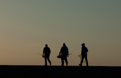 Silhouette of fishermen walking